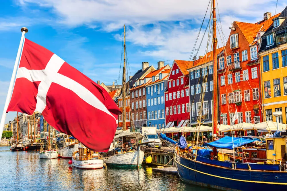 Danish flag and colourful Nyhavn waterfront in Copenhagen