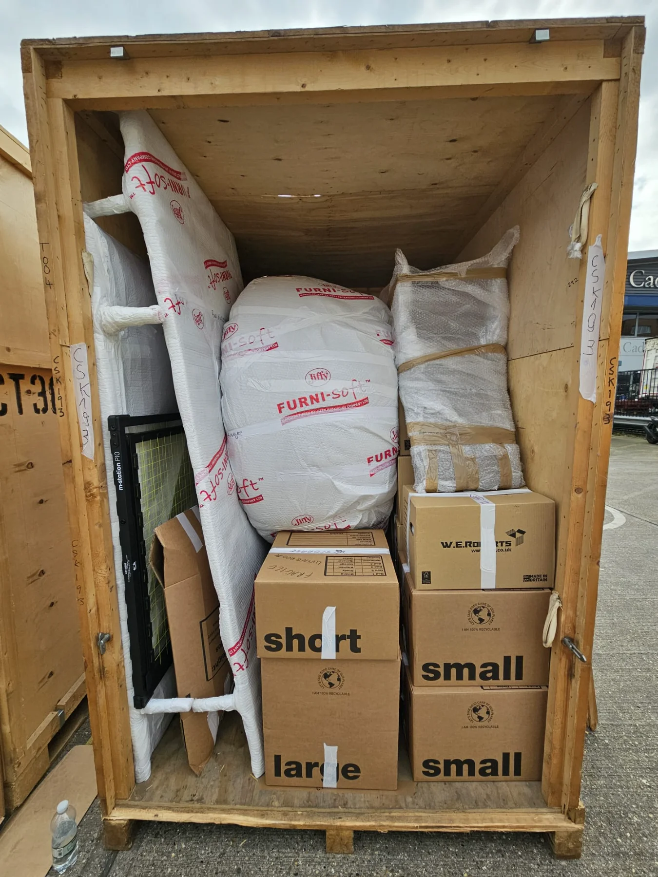 Household furniture and cartons professionally wrapped inside a wooden export crate